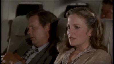 Woman with an anxious look on her face, sitting in a seat on an airplane -- from that great classic, Airplane!